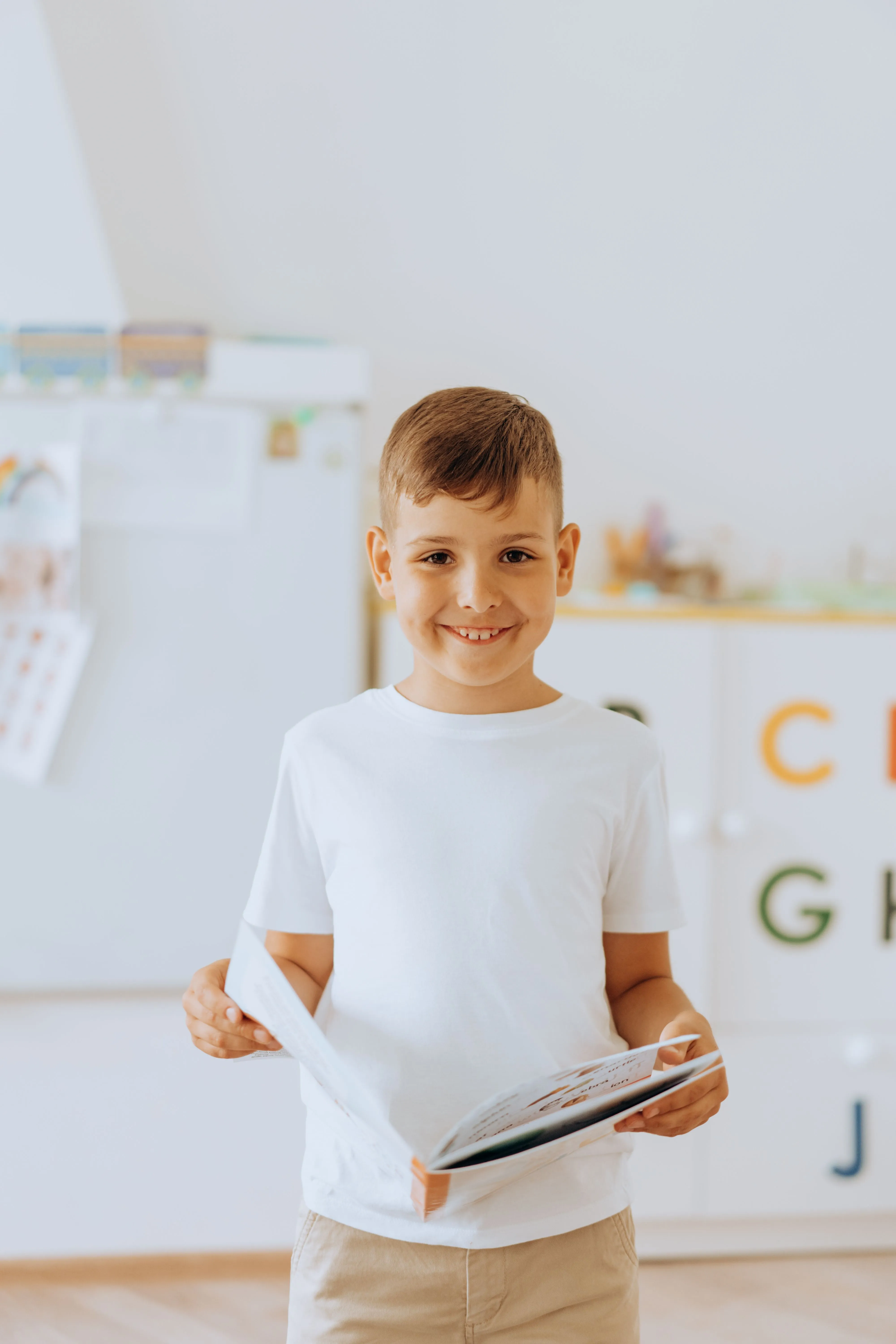 Niño con un libro y letras del abecedario